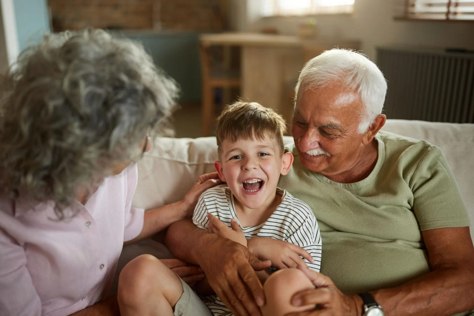 Grandparents laughing with their grandchild